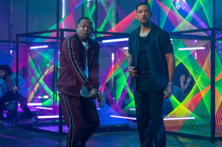 A vibrant HD desktop wallpaper featuring Will Smith and Martin Lawrence in a scene from the movie Bad Boys: Ride or Die, against a backdrop of colorful neon lights.