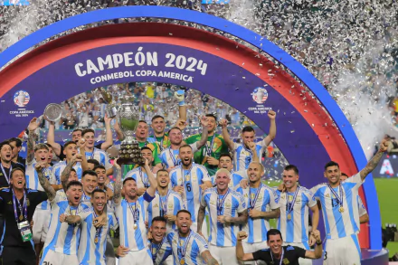 Argentina National Football Team celebrating their victory at the 2024 Copa America, with players holding the trophy under a colorful arch adorned with confetti.