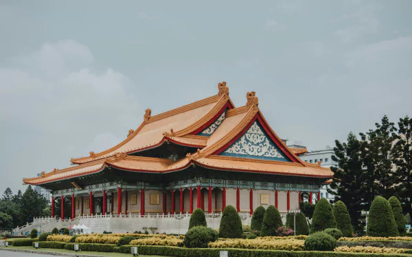 HD desktop wallpaper of a traditional Taiwanese temple with intricate architecture, featuring red columns and ornate roof designs, amidst lush greenery and a cloudy sky background.