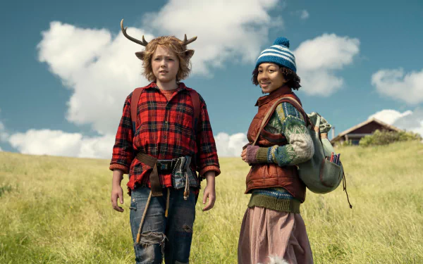 HD desktop wallpaper of the TV show Sweet Tooth featuring Gus, portrayed by Christian Convery, and a companion, standing in an open field with a house in the background.