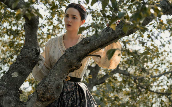Ella Hunt in character from Horizon: An American Saga - Chapter 1, set amidst a tree, featured in a high definition desktop wallpaper and background image.