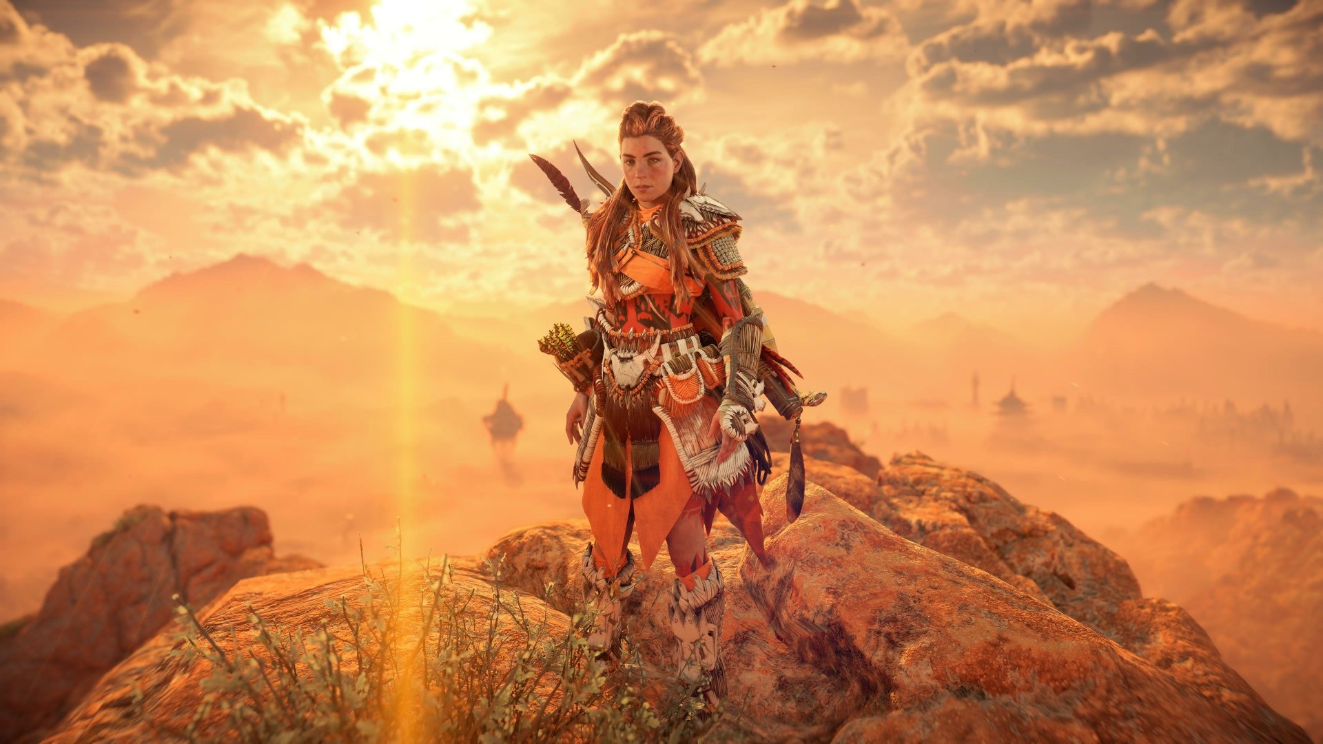 Aloy from Horizon Forbidden West stands on rocky terrain under a dramatic sunset sky, rendered in stunning 4K Ultra HD for PlayStation 5 and PC desktop backgrounds.