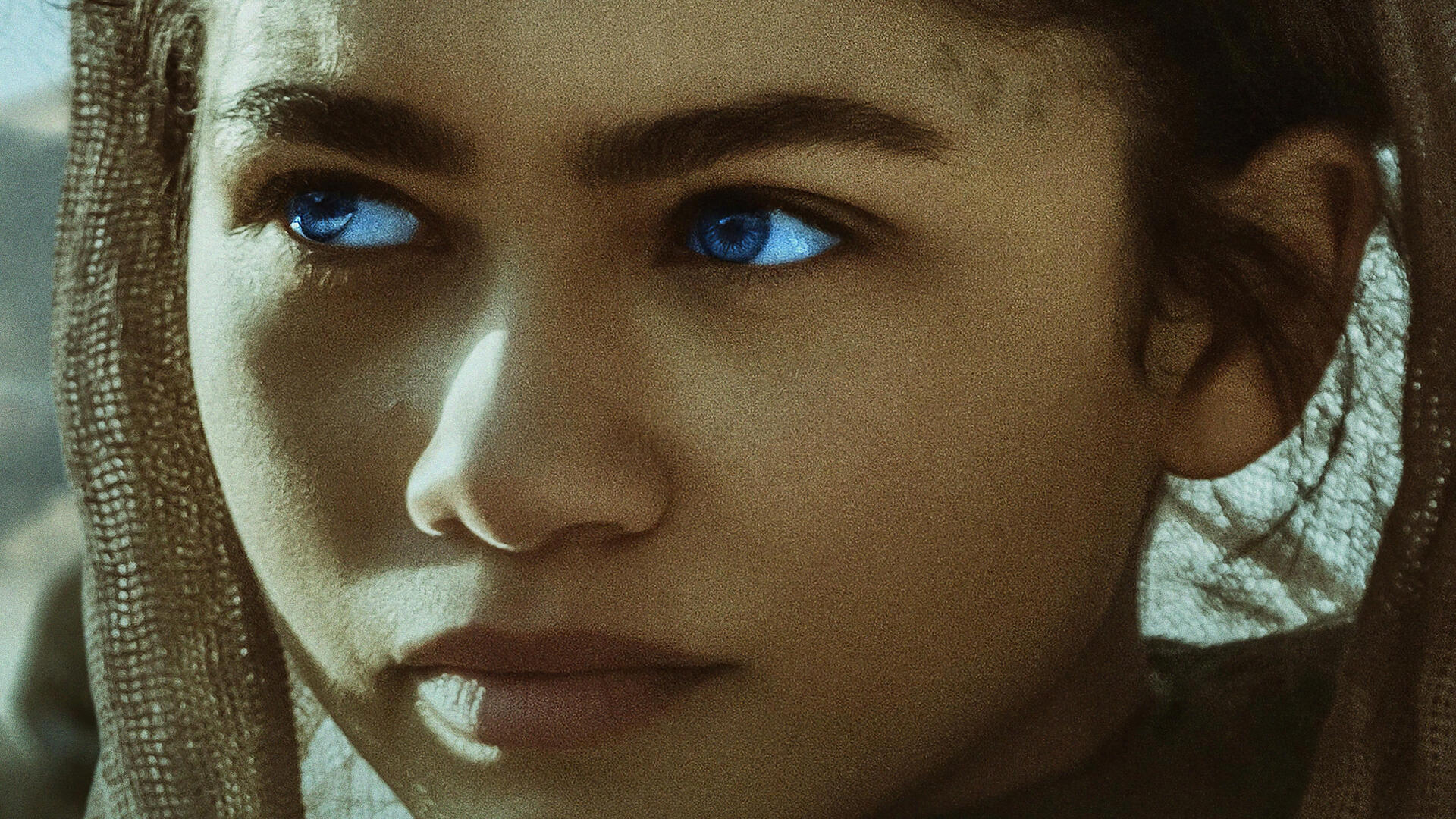 A dramatic HD wallpaper featuring Zendaya from the movie Dune (2021), capturing the film's immersive atmosphere and visual style.