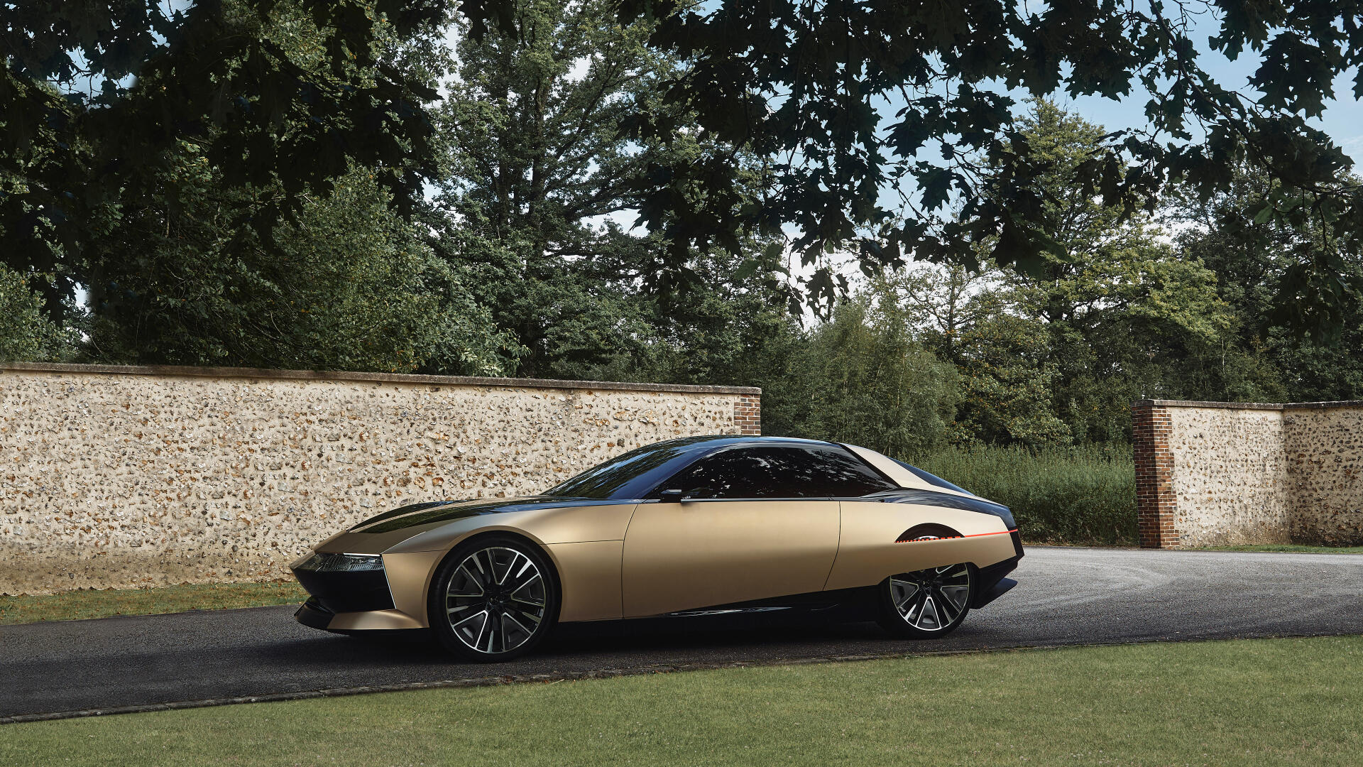 A sleek DS SM Tribute car parked beside a stone wall under trees, captured in a 4K Ultra HD PC desktop wallpaper and background.