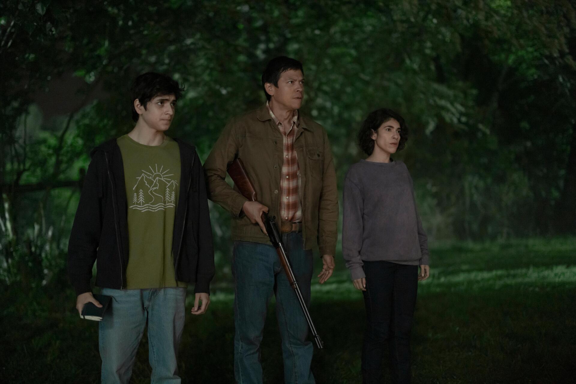 A still from the TV show Teacup (2024), featuring three characters in a dimly lit, wooded setting, conveying a sense of tension and anticipation. This 8K Ultra HD image serves as a striking desktop wallpaper.