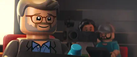 A colorful HD desktop wallpaper from the movie Piece by Piece, featuring LEGO characters, including a smiling figure with glasses, set against a cinematic backdrop.