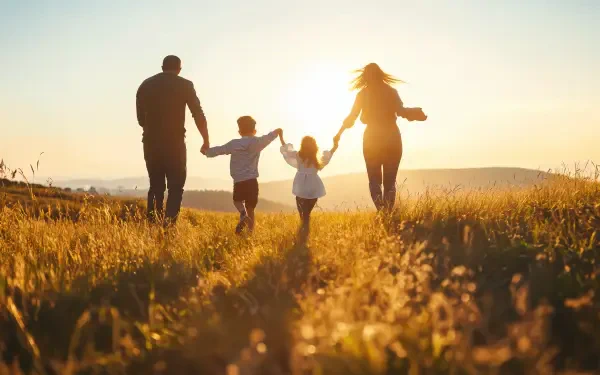 A happy family walks hand in hand through a sunlit field, capturing a joyful moment in a beautiful 4K Ultra HD desktop wallpaper.
