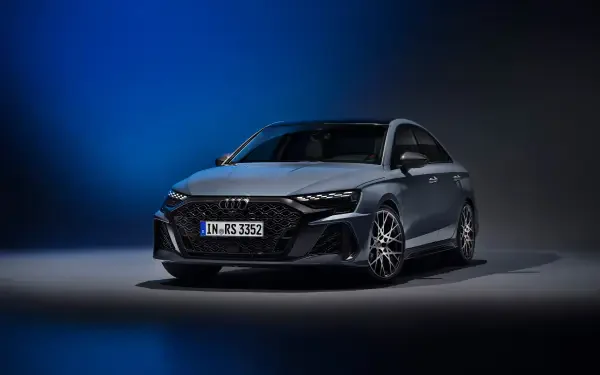An Audi RS3 Sedan stands prominently against a dark background, showcasing its sleek design and dynamic lines in this stunning 4K Ultra HD desktop wallpaper.
