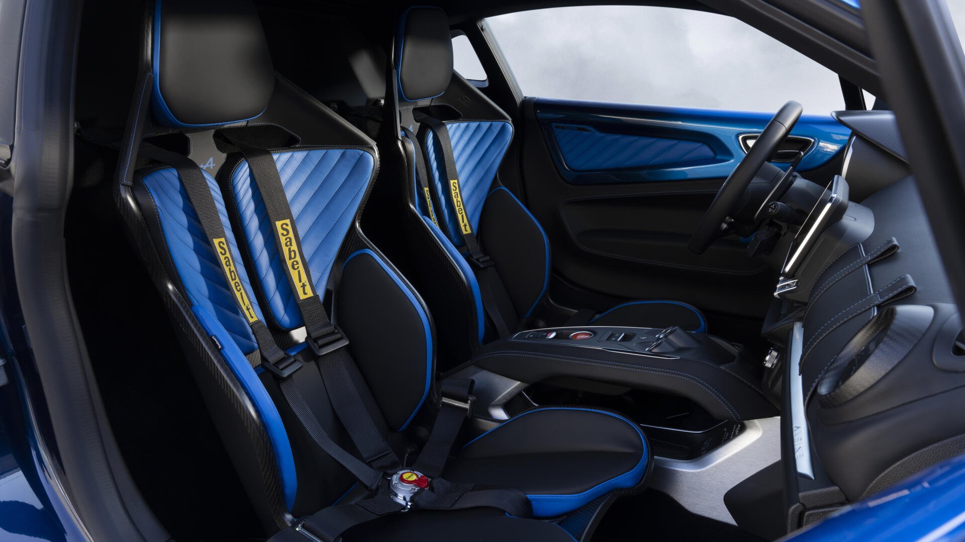 A striking interior view of the Alpine A110 R Ultime, showcasing sleek design elements, sport seats with blue accents, and high-tech instrumentation, set against a minimalist backdrop.