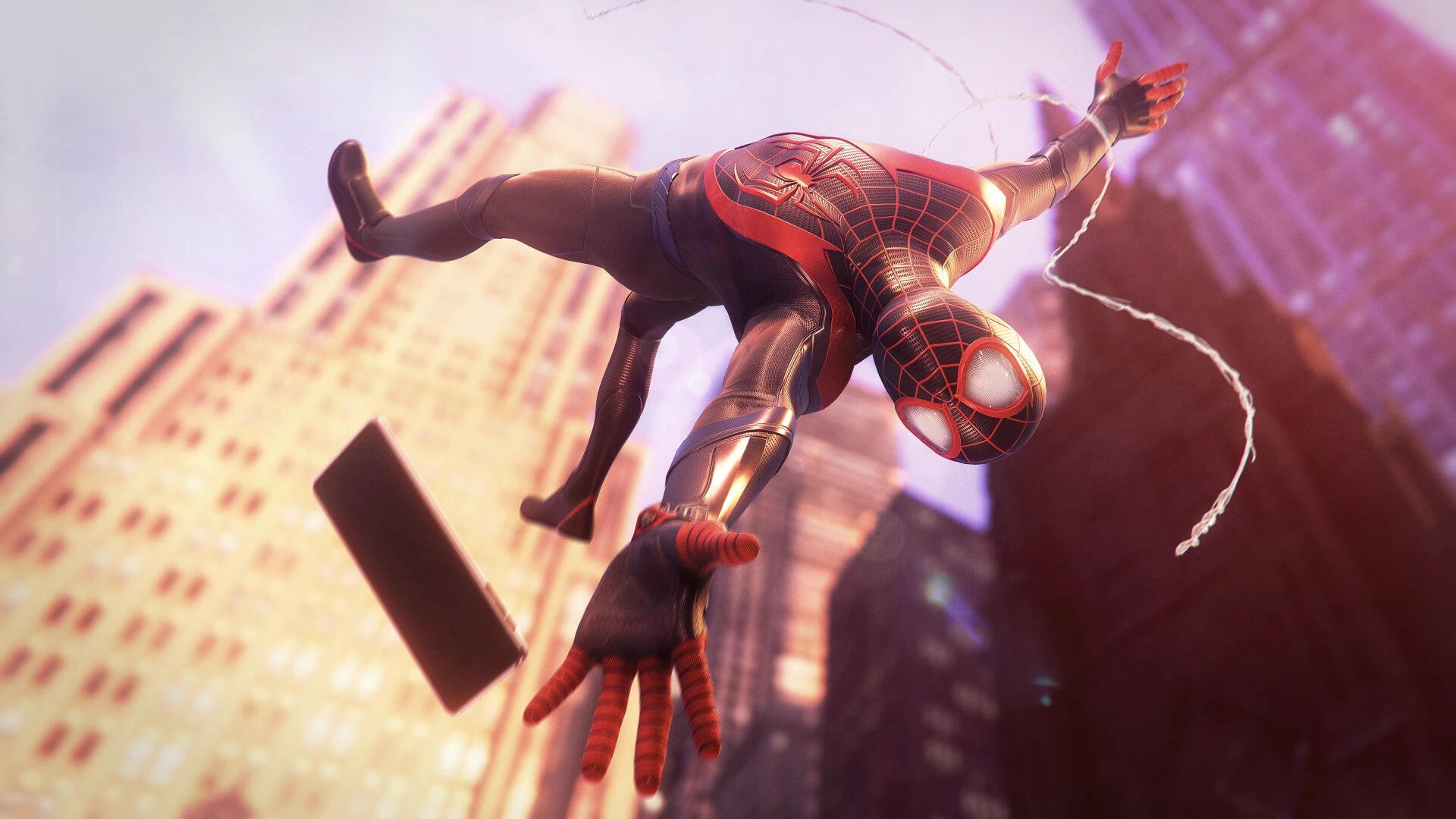 Miles Morales in his Spider-Man suit swings dynamically through a glowing cityscape, featured in a vibrant 4K Ultra HD PC desktop wallpaper from Marvel's Spider-Man: Miles Morales.