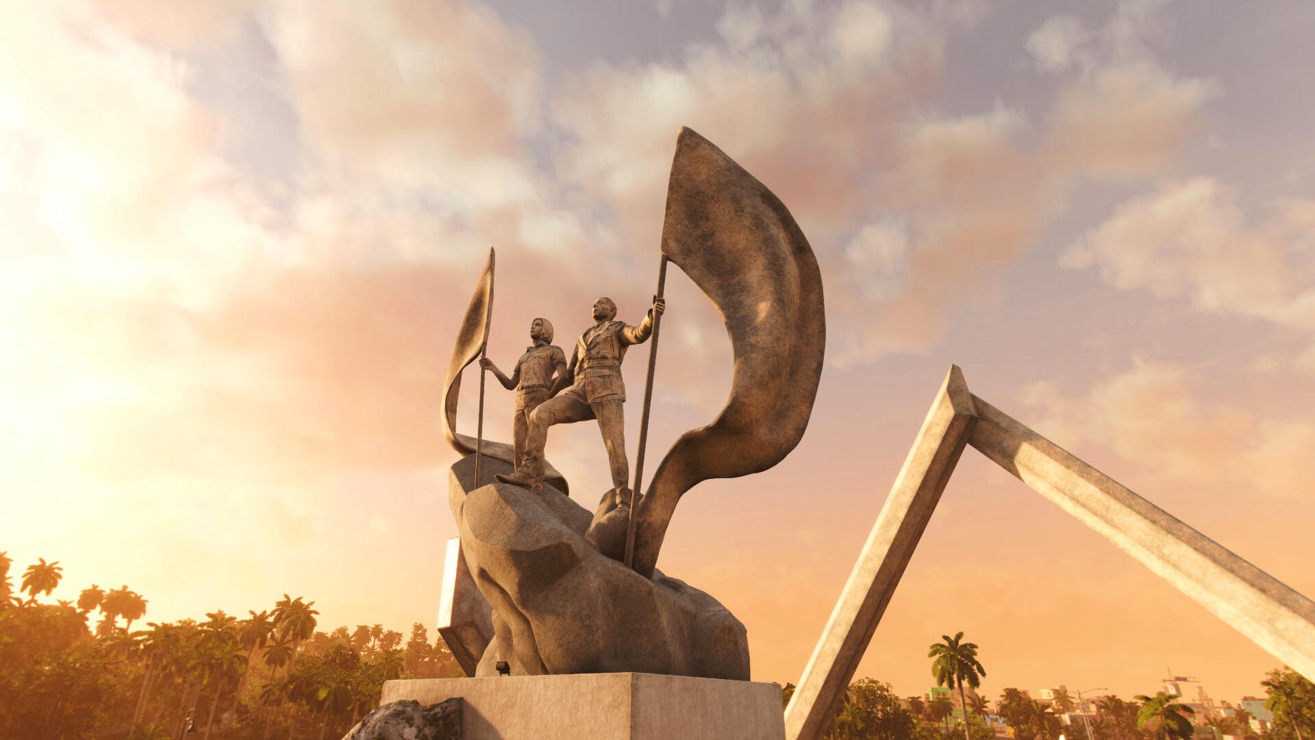 A striking 4K Ultra HD wallpaper from Far Cry 6, featuring a bronze statue of two revolutionaries holding flags against a vibrant sunset backdrop.