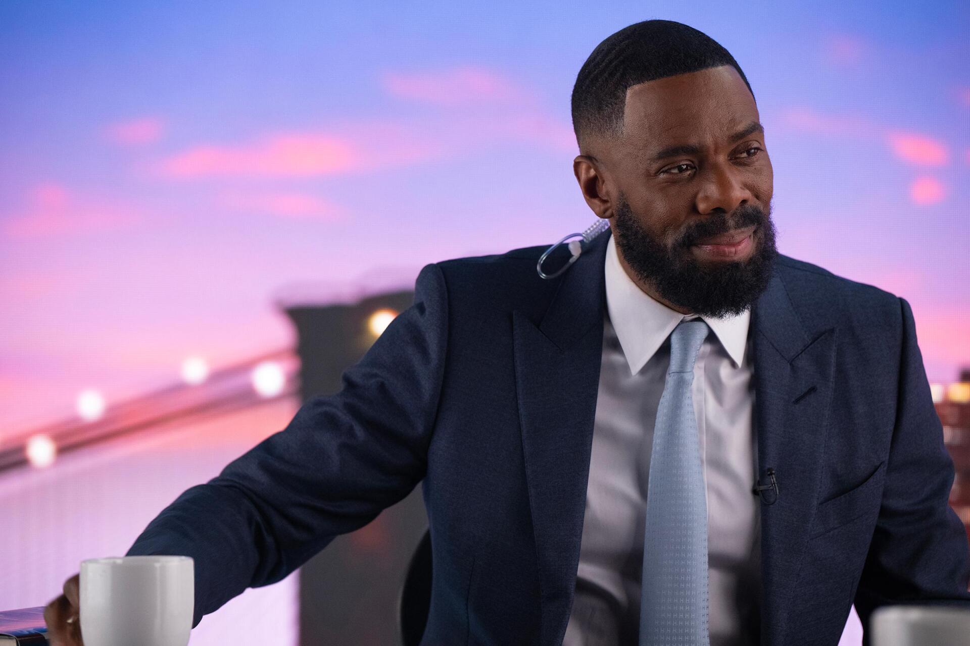 Colman Domingo appears in a suit, seated with a cup, against a colorful backdrop, promoting his role in the TV show The Madness. This HD wallpaper captures his engaging presence.