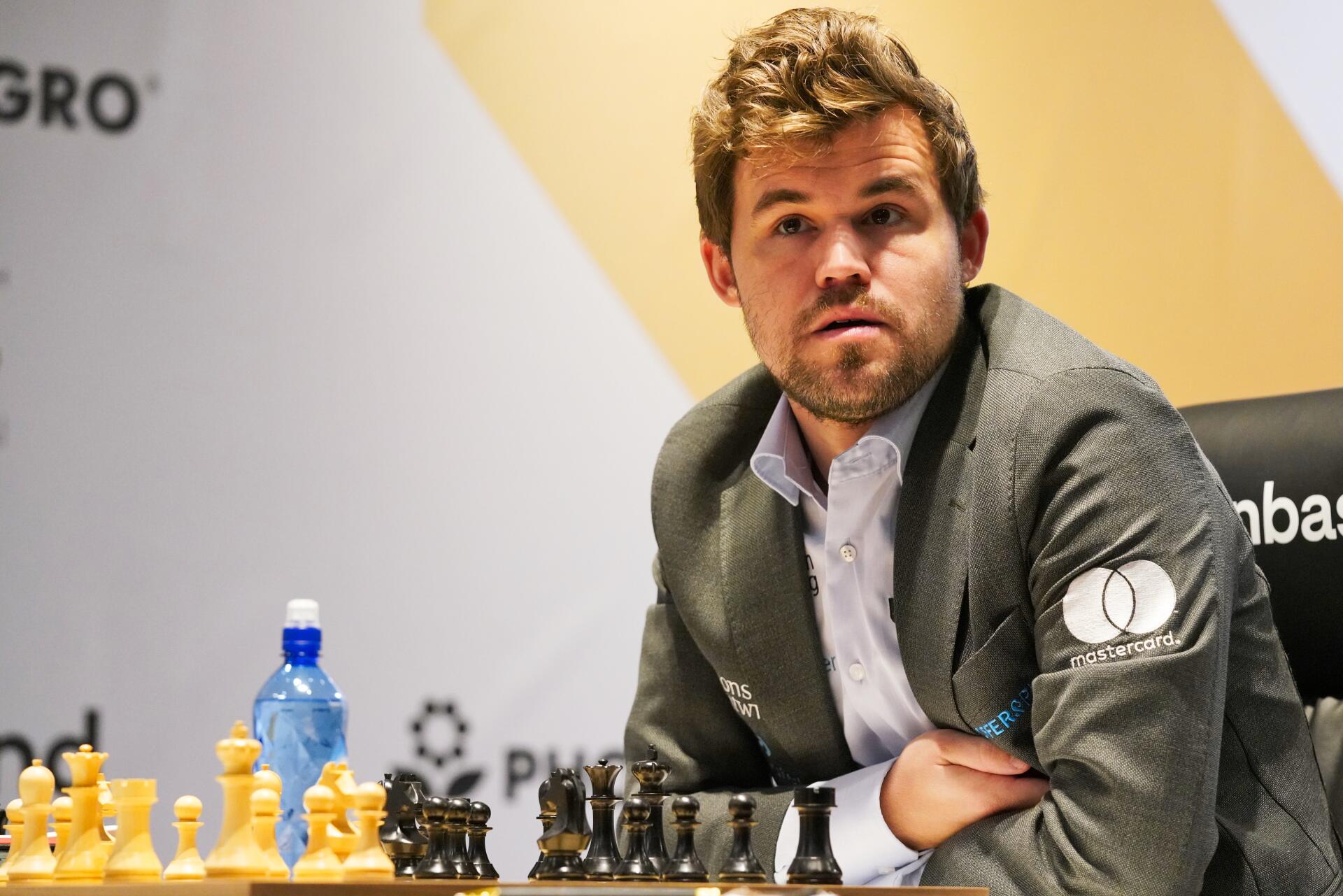 Magnus Carlsen ponders his next move at a chess tournament, surrounded by pieces on a board. This dynamic image serves as a vibrant 4K Ultra HD desktop wallpaper for sports and chess enthusiasts.