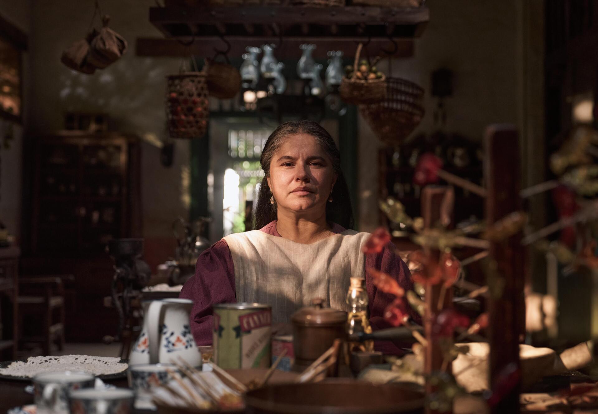 A character from the TV show One Hundred Years of Solitude sits thoughtfully in a richly decorated interior, captured in stunning 8K Ultra HD.