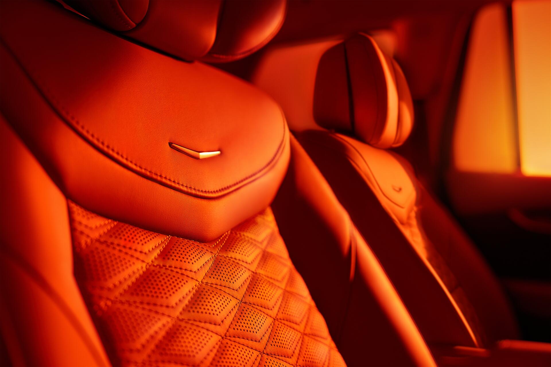 Close-up of luxurious orange leather seats in a Cadillac XT6, showcasing detailed stitching and design. This 4K Ultra HD wallpaper highlights the elegance of automotive interiors.