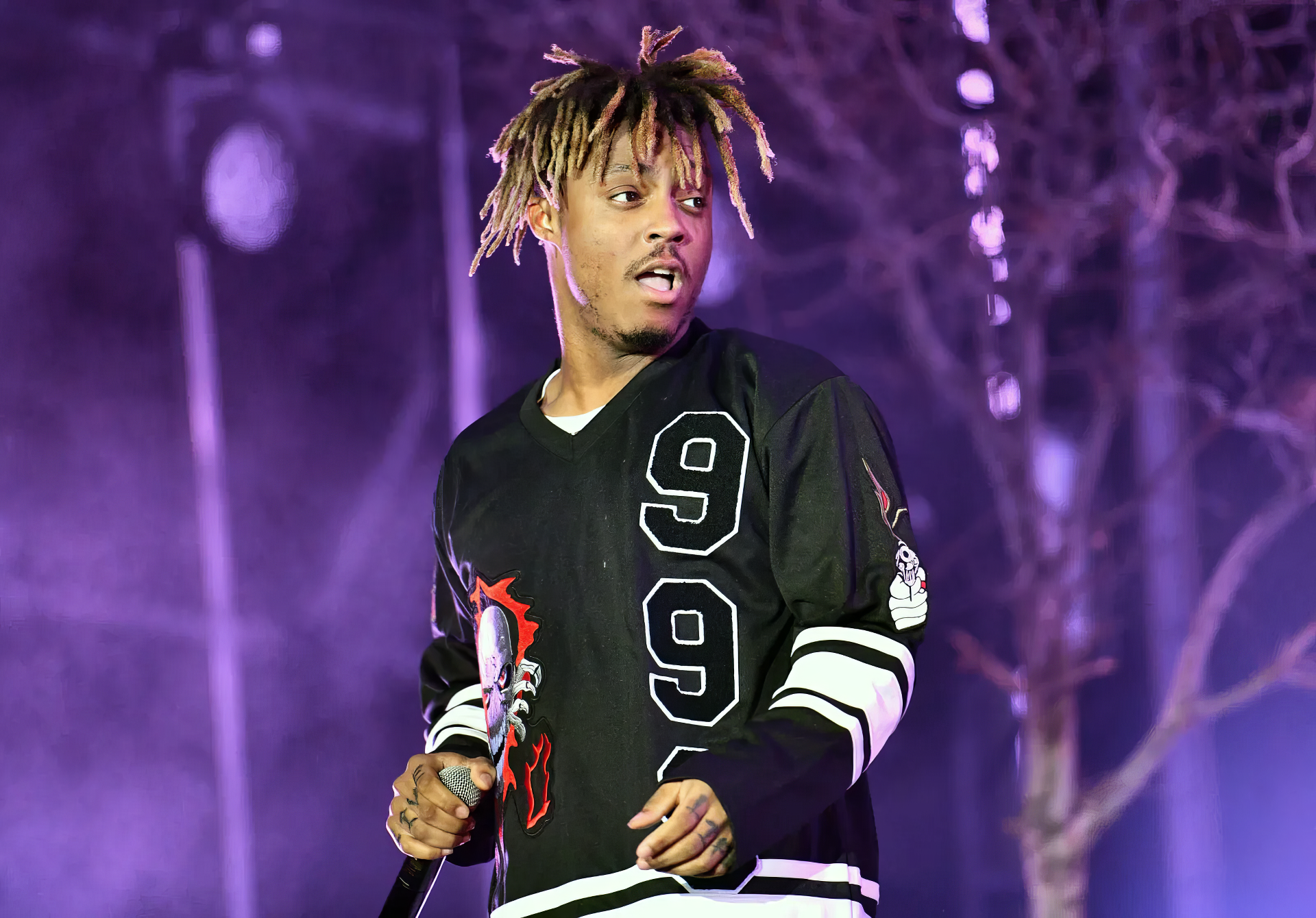 HD PC desktop wallpaper featuring rapper Juice Wrld performing on stage with purple lighting in the background.