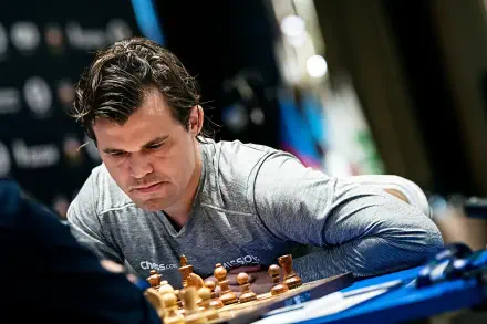 Magnus Carlsen intensely focuses on a chess game, surrounded by pieces and a competition backdrop, making this image a striking HD desktop wallpaper for sports and chess enthusiasts.