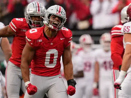 A dynamic Ohio State Buckeyes player celebrating on the field, captured in high definition. This sports-themed HD wallpaper showcases team spirit and athleticism.