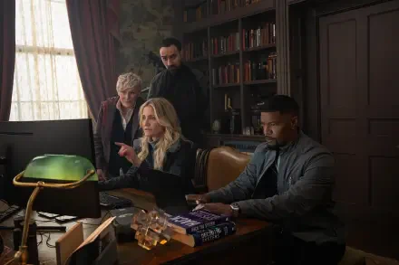 Cameron Diaz and Jamie Foxx appear in a scene from the movie Back in Action, focusing intently at a computer with two others in a well-furnished office setting.