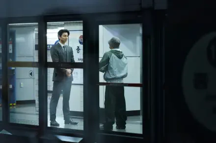 A scene from the TV show Squid Game, featuring two characters in a dimly lit subway station. The dramatic setting is captured in 4K Ultra HD quality.