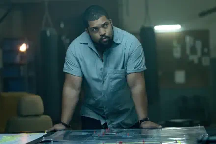 O'Shea Jackson Jr. leans over a table in a dimly lit room, analyzing a scenario in the film Den of Thieves 2: Pantera. This image is a striking 4K Ultra HD desktop wallpaper.