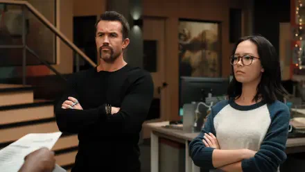 A scene from Mythic Quest featuring Rob McElhenney and Charlotte Nicdao, both with serious expressions, standing in a modern office environment. 4K Ultra HD wallpaper.
