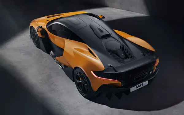 A striking McLaren W1 showcases its sleek design in this 8K Ultra HD desktop wallpaper, featuring an eye-catching orange and black color scheme against a dramatic backdrop.