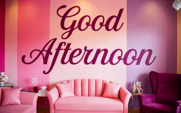 A vibrant interior featuring a pink sofa and armchair against a colorful wall, prominently displaying the phrase Good Afternoon, designed for a cheerful atmosphere. 4K Ultra HD quality.