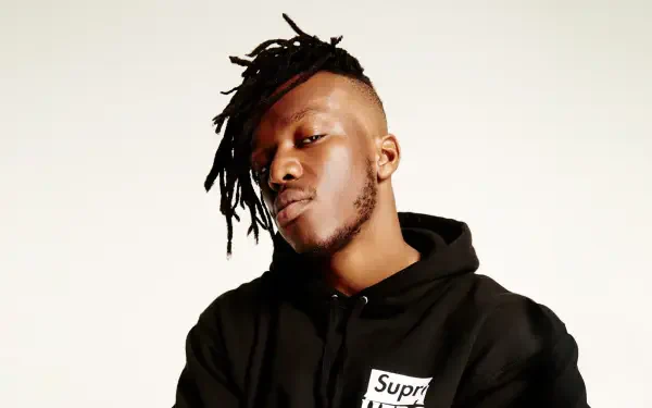 A high-definition desktop wallpaper featuring KSI, showcasing his distinctive style with dreadlocks and a confident expression, set against a simple background.