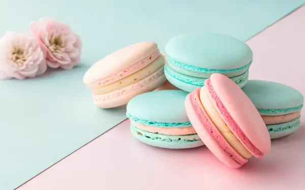 Aesthetic pastel-colored macarons arranged on a soft background, complemented by delicate flowers, creating a serene 4K Ultra HD desktop wallpaper and background.