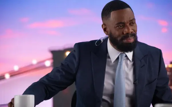 Colman Domingo appears in a suit, seated with a cup, against a colorful backdrop, promoting his role in the TV show The Madness. This HD wallpaper captures his engaging presence.