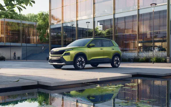 A Škoda Kylaq parked by a modern building, reflecting in a serene pool. This vibrant green SUV captures attention in this 4K Ultra HD desktop wallpaper.