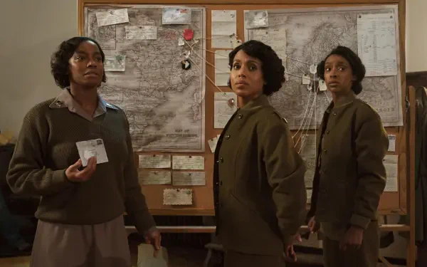 A dramatic scene from the movie The Six Triple Eight, featuring three women in period attire, standing in front of a detailed map with notes and photographs, set against a historic backdrop.