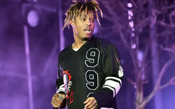 Juice Wrld performing on stage with vibrant lights in the background, captured in a dynamic moment, perfect as a music-themed HD desktop wallpaper.