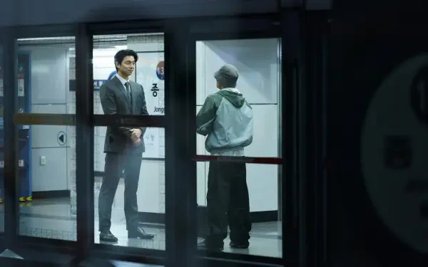 A scene from the TV show Squid Game, featuring two characters in a dimly lit subway station. The dramatic setting is captured in 4K Ultra HD quality.