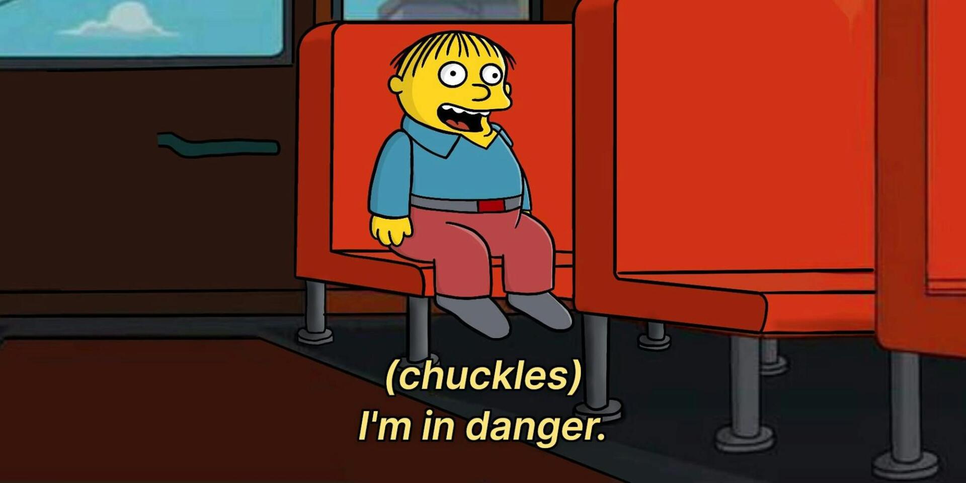 Ralph Wiggum from The Simpsons sits on a bus seat, chuckling and saying, (chuckles) I'm in danger. This image serves as a playful meme in the show's context.