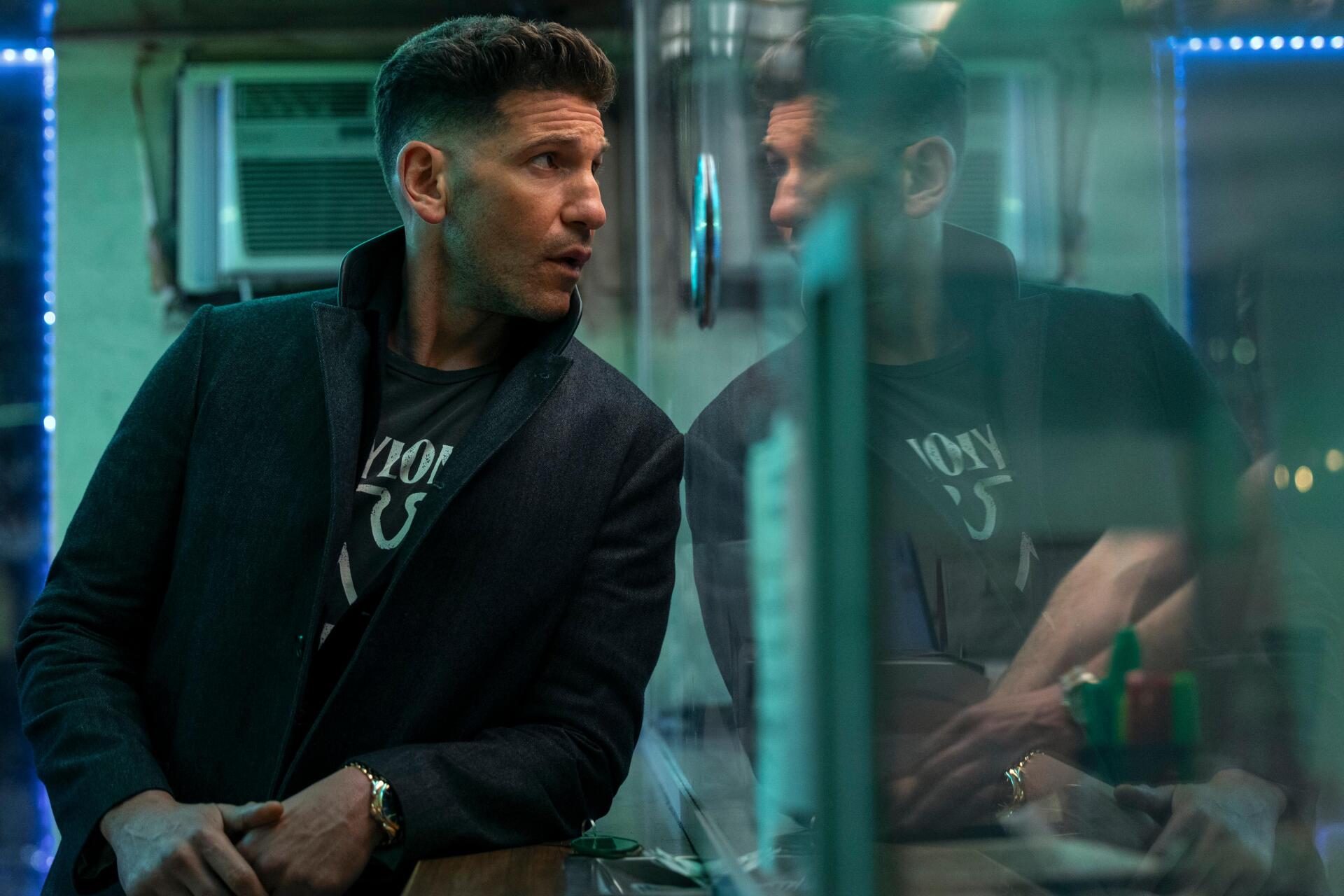Jon Bernthal stars in The Accountant 2, depicted in a dramatic moment with reflections, showcased in a striking 4K Ultra HD wallpaper.