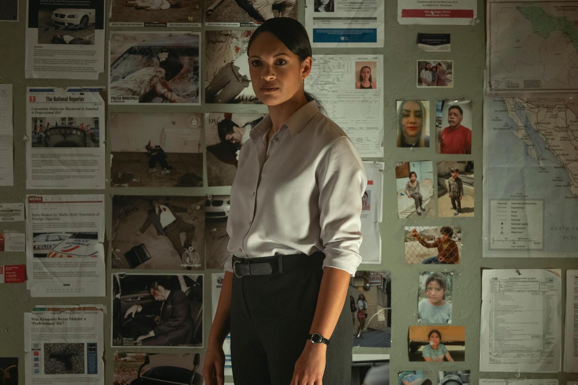 A scene from *The Accountant 2* features Cynthia Addai-Robinson in front of a wall covered with photographs and documents, creating a tense and investigative atmosphere. 4K Ultra HD wallpaper.