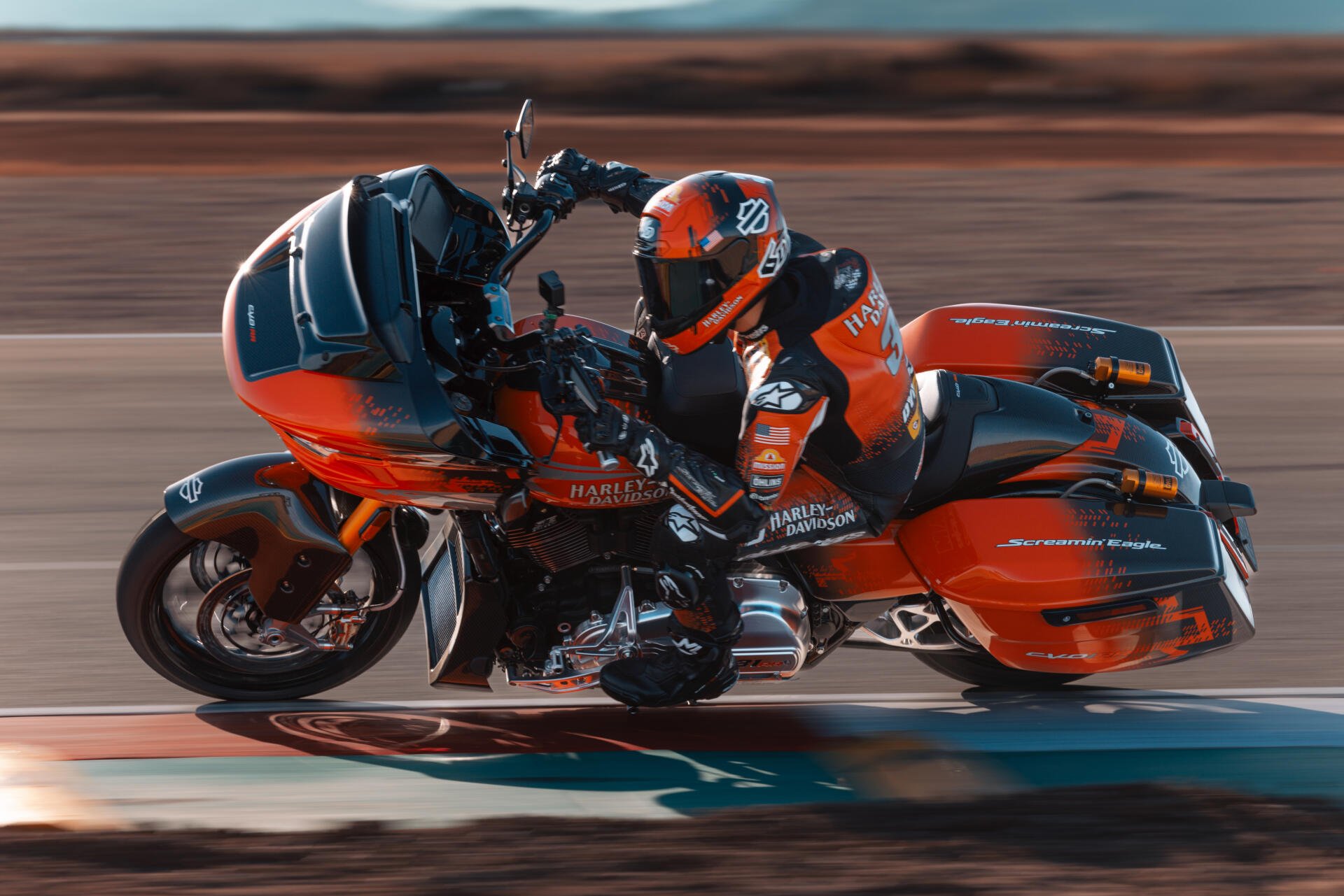 A vibrant 4K Ultra HD wallpaper of a Harley-Davidson CVO Road Glide RR motorcycle with a rider in matching gear, captured in dynamic motion on a road.