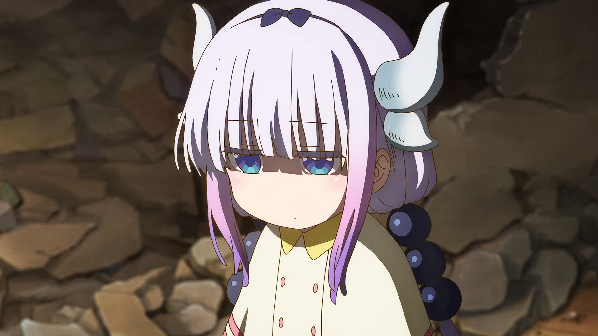 Kanna Kamui from Miss Kobayashi's Dragon Maid, HD PC desktop wallpaper: solemn expression, white-and-pink hair with horn-like accessories, pale coat, beaded braid against a rocky background.