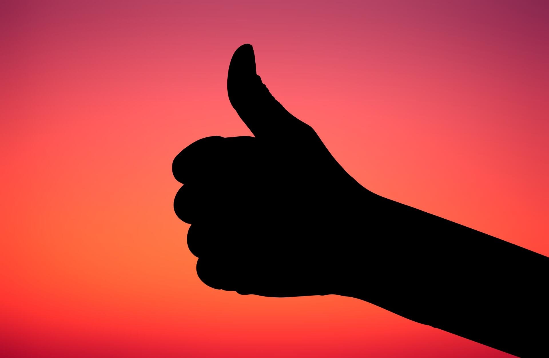 Silhouette of a hand giving a thumbs-up against a vivid sunset gradient — HD PC desktop wallpaper and background.