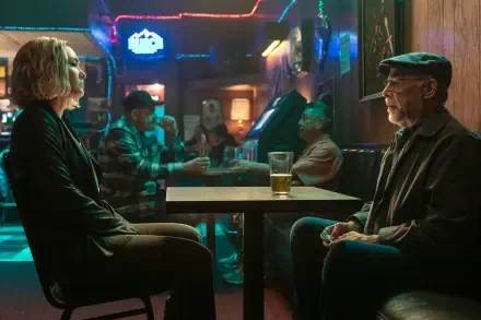 A 4K Ultra HD wallpaper featuring scenes from The Accountant 2, showcasing J.K. Simmons and Daniella Pineda in a bar setting, with a vibrant ambiance and background characters.