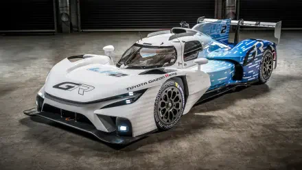 Sleek Toyota race car with aerodynamic design, captured in 8K Ultra HD, showcasing advanced performance and striking blue-white color scheme on a concrete floor.