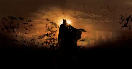 Batman Begins 4K Ultra HD PC Desktop Wallpaper and Background - silhouetted Batman stands amid a swirl of bats against a fiery orange city skyline.
