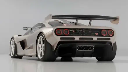 Silver Gordon Murray Automotive sports vehicle, rear three-quarter view with large wing, triple center exhausts and round taillights — HD PC desktop wallpaper background.