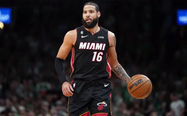 Caleb Martin of the Miami Heat dribbles the basketball during an NBA game, showcasing his skills in this vibrant 4K Ultra HD desktop wallpaper.