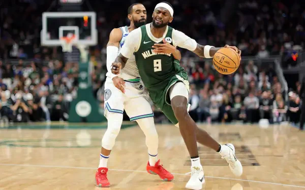 Bobby Portis Jr. of the Milwaukee Bucks dribbles the ball while being closely guarded by Mike Conley Jr. in this dynamic NBA action shot, capturing the intensity of the game.
