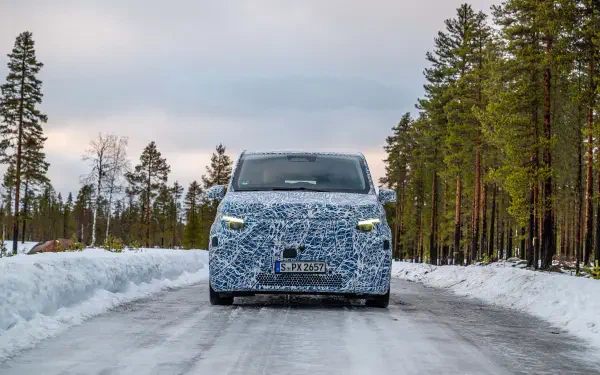 A Mercedes-Benz MPV covered in camouflage pattern drives on a snowy road, surrounded by tall trees, captured in stunning 8K Ultra HD resolution.