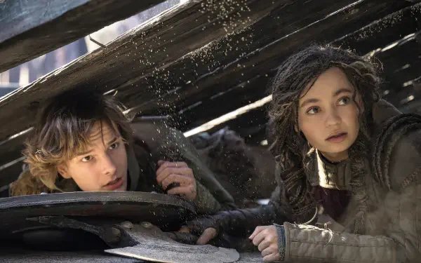 Hiccup and Astrid from How to Train Your Dragon (2025) peering out from under debris, showcasing a moment of tension and adventure in this 4K Ultra HD wallpaper.