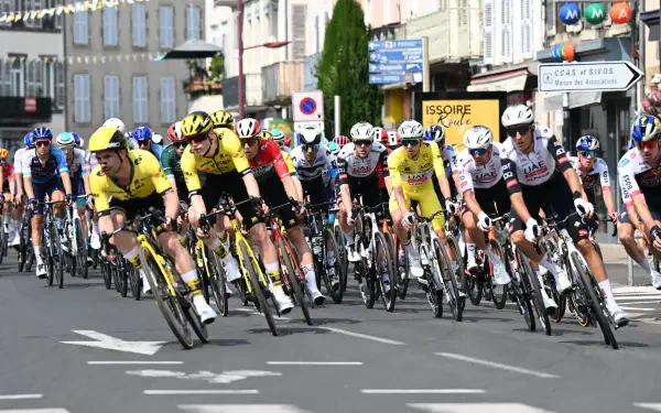 Cyclists race intensely in the Critérium du Dauphiné, with riders tightly packed on city streets in this 4K Ultra HD sports cycling competition wallpaper.